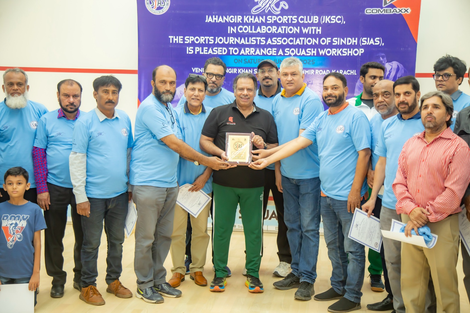 On the occasion of the Squash Reporting Workshop, President of SUJAS Mehmood Riaz and Secretary Shahid Saathi present a commemorative shield to World Squash Legend Jahangir Khan. Also seen in the photo are General Secretary of PSWF Asghar Azeem and other members of SUJAS.